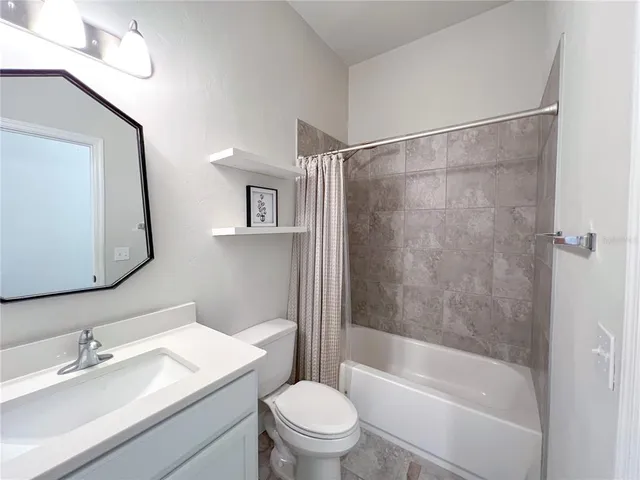 a bathroom with a bathtub toilet sink vanity and mirror