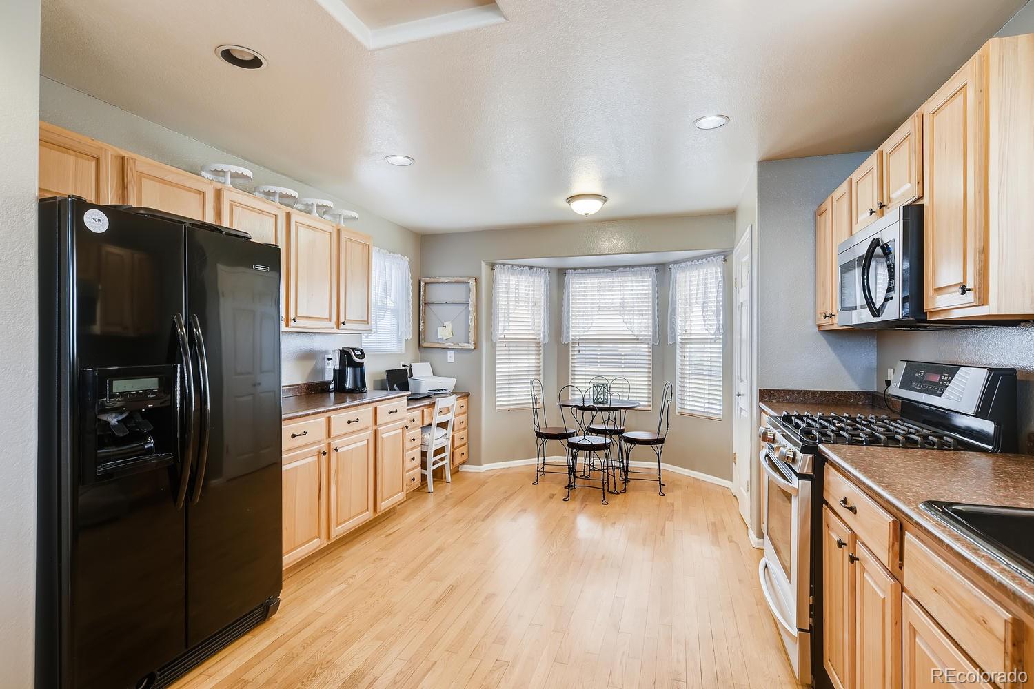 11613 Rio Secco Road Peyton, CO 80831 - Photo 10 of 36 a kitchen with stainless steel appliances granite countertop a refrigerator stove microwave and sink