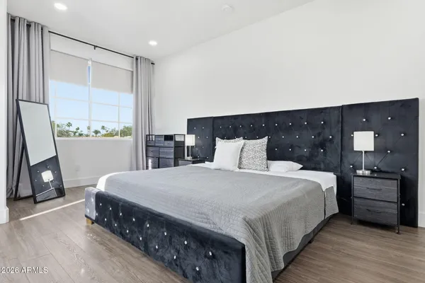 a bedroom with a bed and a large mirror