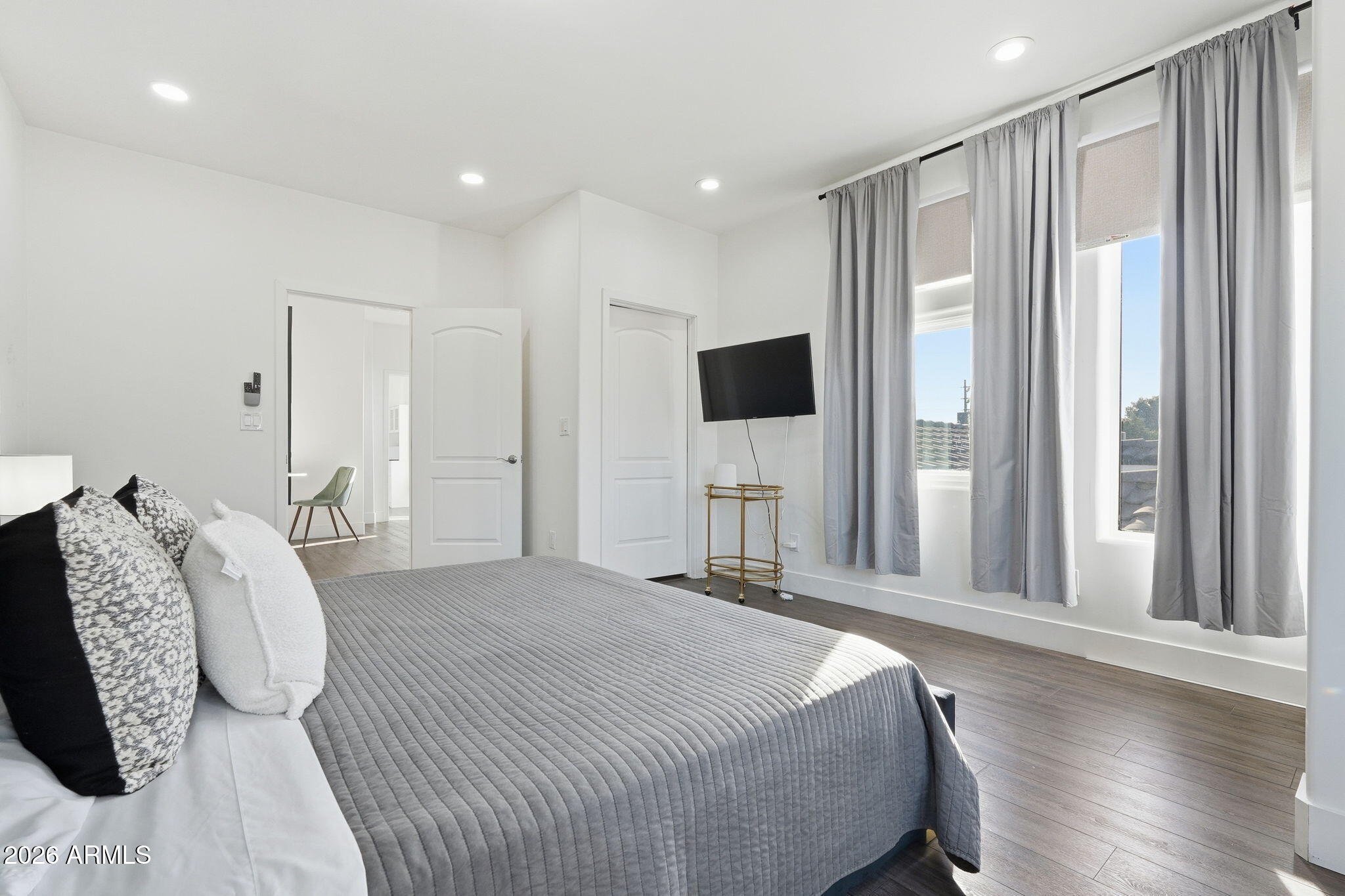 5009 East Wethersfield Road Scottsdale, AZ 85254 - Photo 12 of 30 a spacious bedroom with a bed and a large mirror