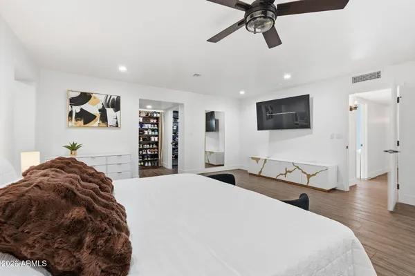 a spacious bedroom with a bed and a flat screen tv