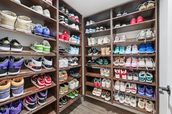 a view of walk in closet with clothes and shoes