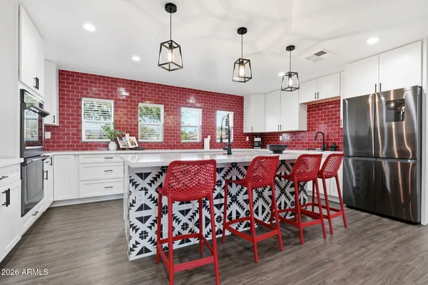 a kitchen with stainless steel appliances a dining table chairs stove and cabinets