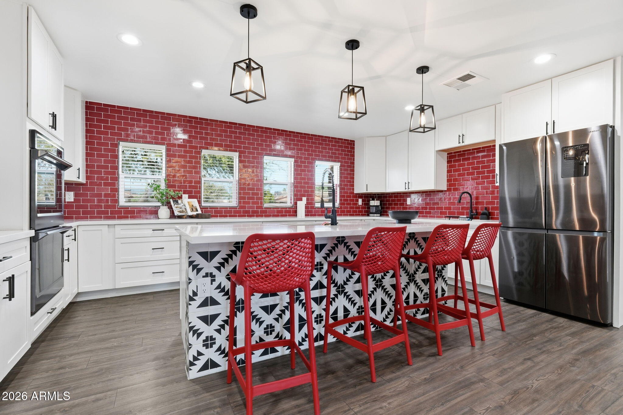 5009 East Wethersfield Road Scottsdale, AZ 85254 - Photo 20 of 30 a kitchen with stainless steel appliances kitchen island granite countertop a table chairs and a refrigerator