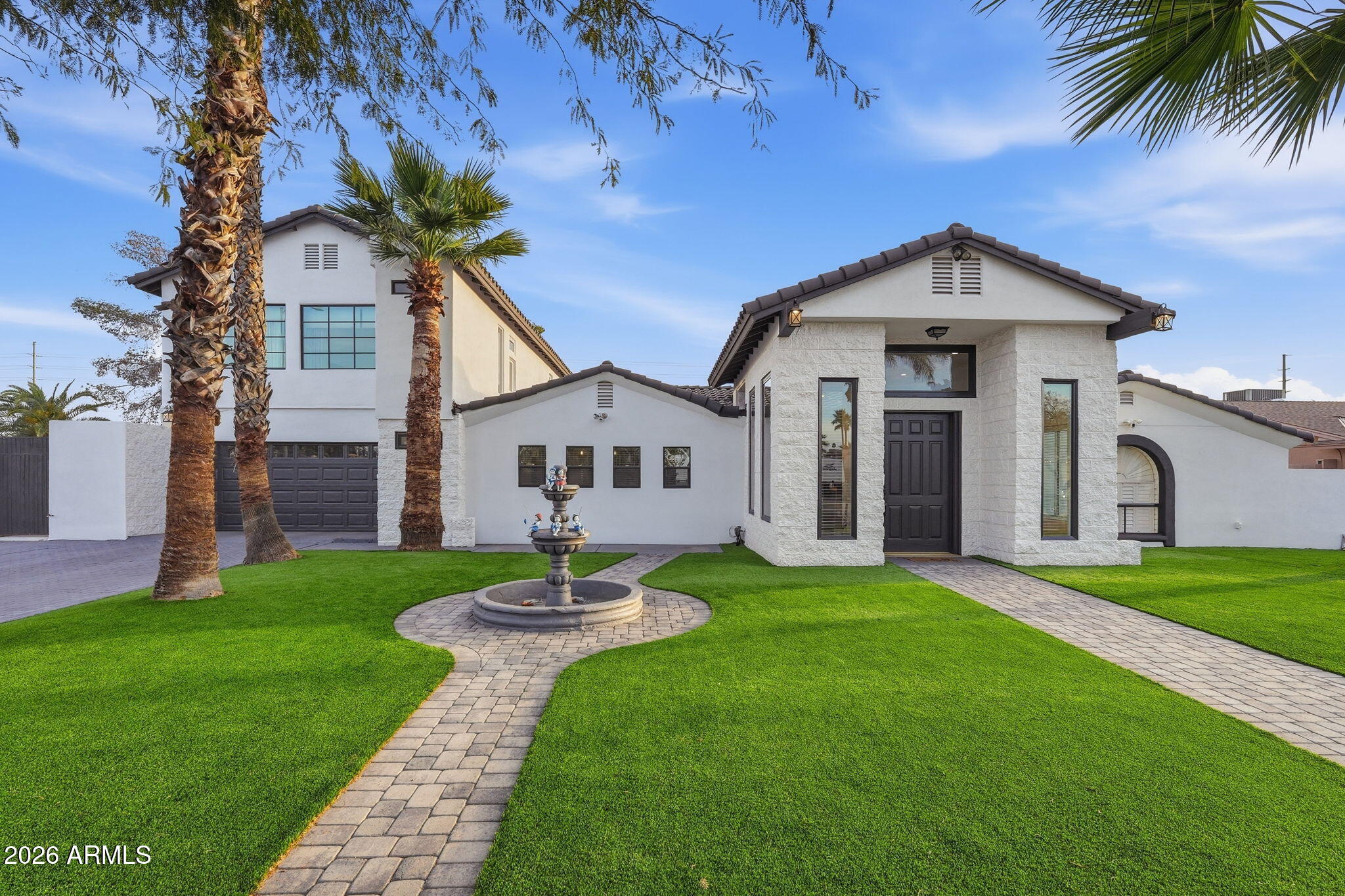 5009 East Wethersfield Road Scottsdale, AZ 85254 - Photo 3 of 30 a front view of a house with a yard and garage