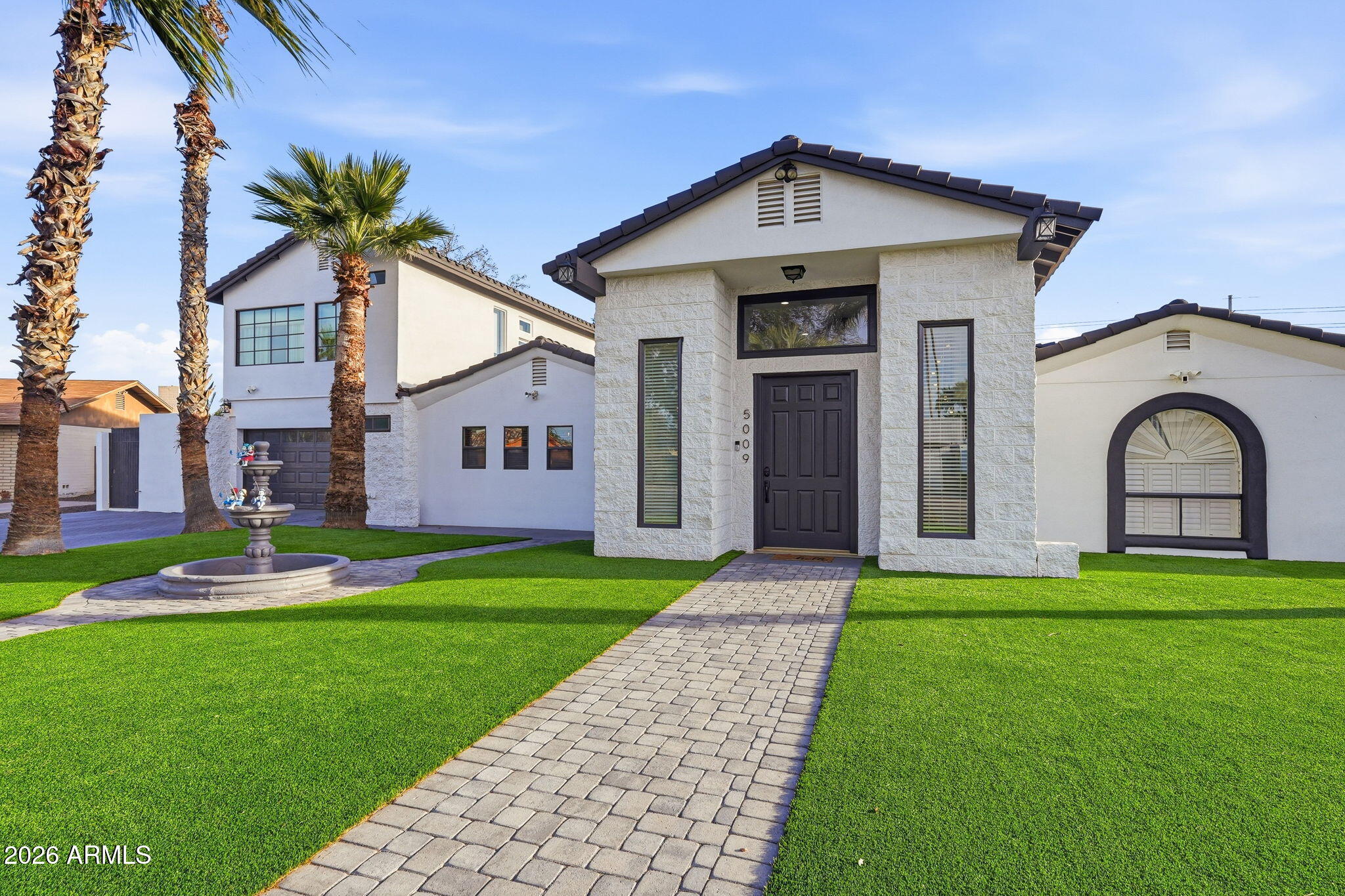 5009 East Wethersfield Road Scottsdale, AZ 85254 - Photo 4 of 30 a front view of a house with a yard and garage