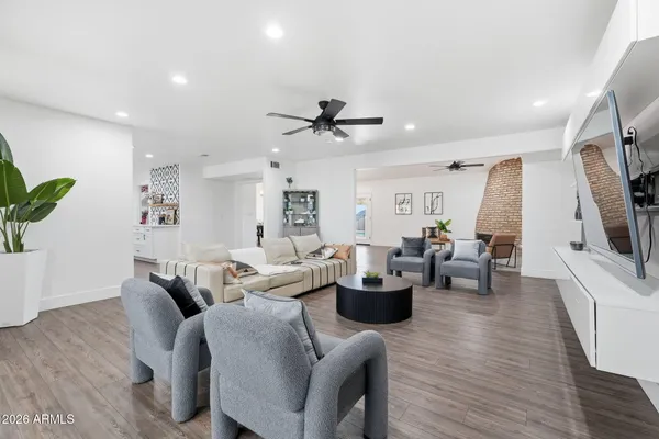a living room with furniture a flat screen tv and kitchen view