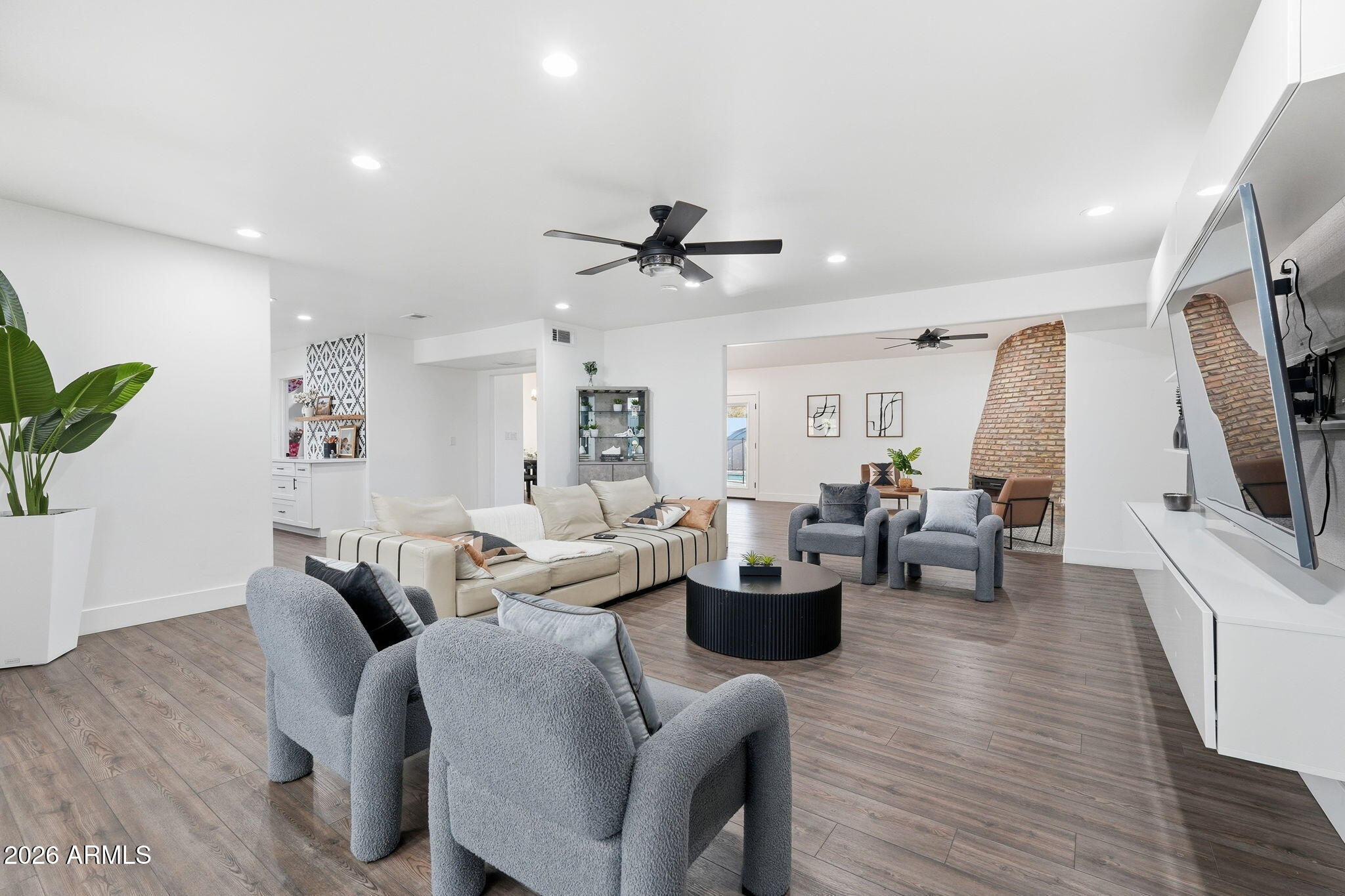 5009 East Wethersfield Road Scottsdale, AZ 85254 - Photo 5 of 30 a living room with furniture a flat screen tv and kitchen view