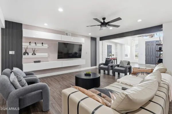 a living room with furniture kitchen view and a flat screen tv