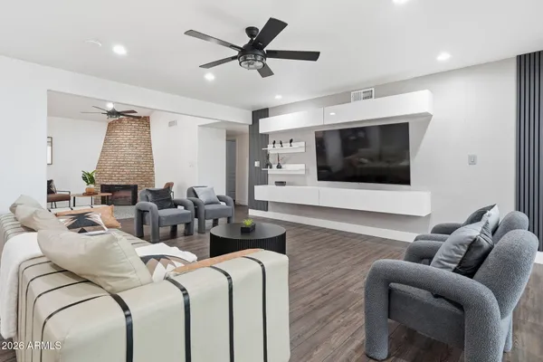 a living room with furniture a flat screen tv and a window