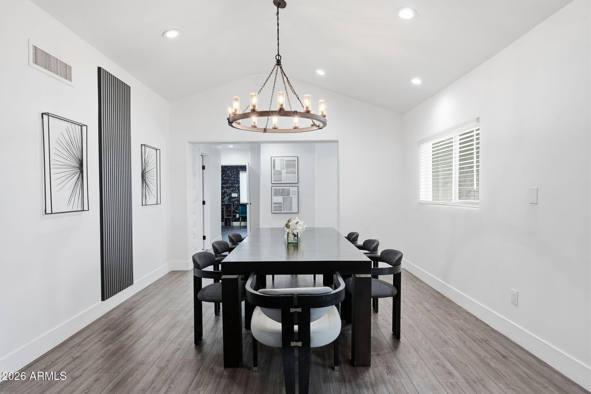 5009 East Wethersfield Road Scottsdale, AZ 85254 - Photo 10 of 30 a dining room with wooden floor a chandelier a wooden table and chairs
