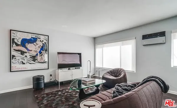 a living room with furniture a couch and a flat screen tv