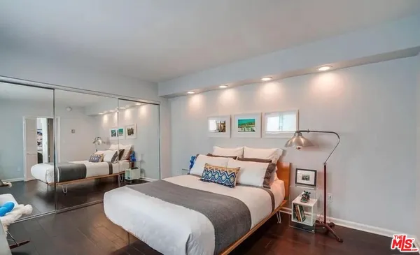 a bedroom with bed and wooden floor