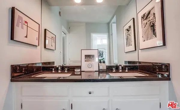 a bathroom with double sink and a mirror