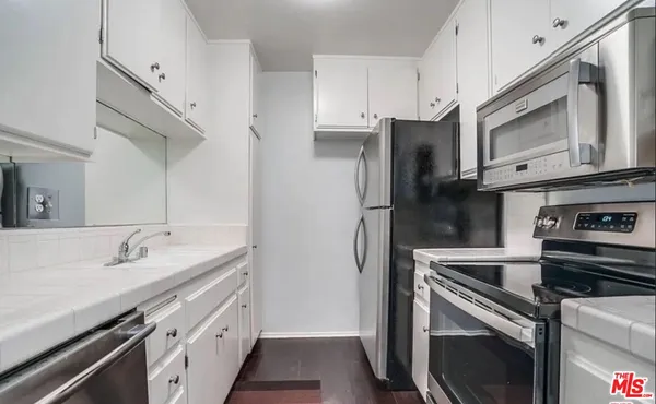 a kitchen with stainless steel appliances a stove microwave and a sink