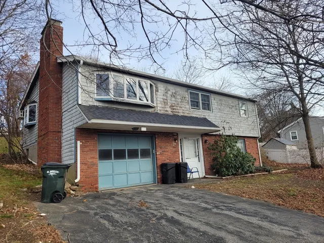a front view of a building with a lots of windows and plants