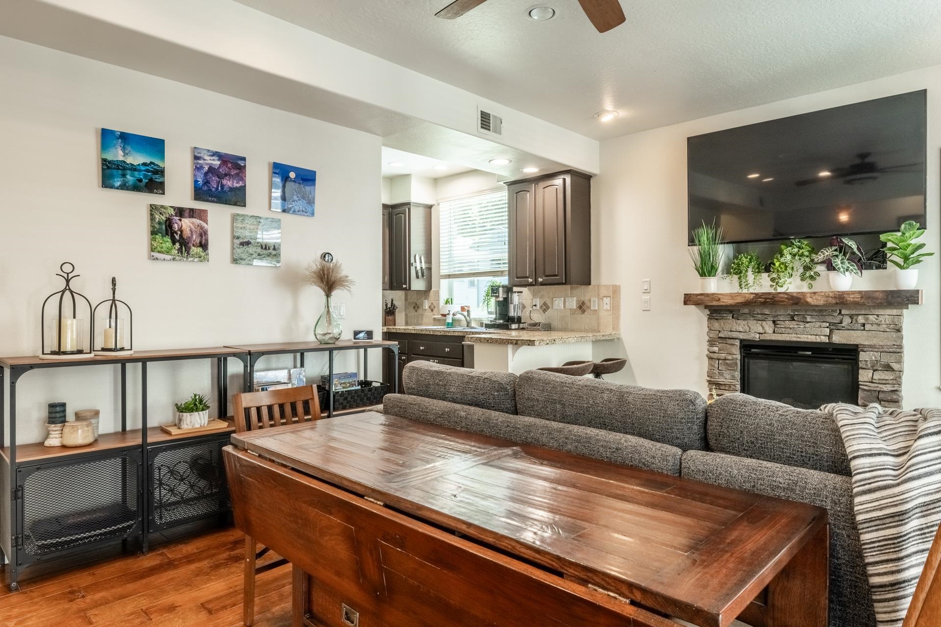 1787 Old Mammoth Road, Unit 2 Mammoth Lakes, CA 93546 - Photo 6 of 29 Living area featuring wood-finish flooring, a stone-faced fireplace with a wood mantle, and a ceiling fan