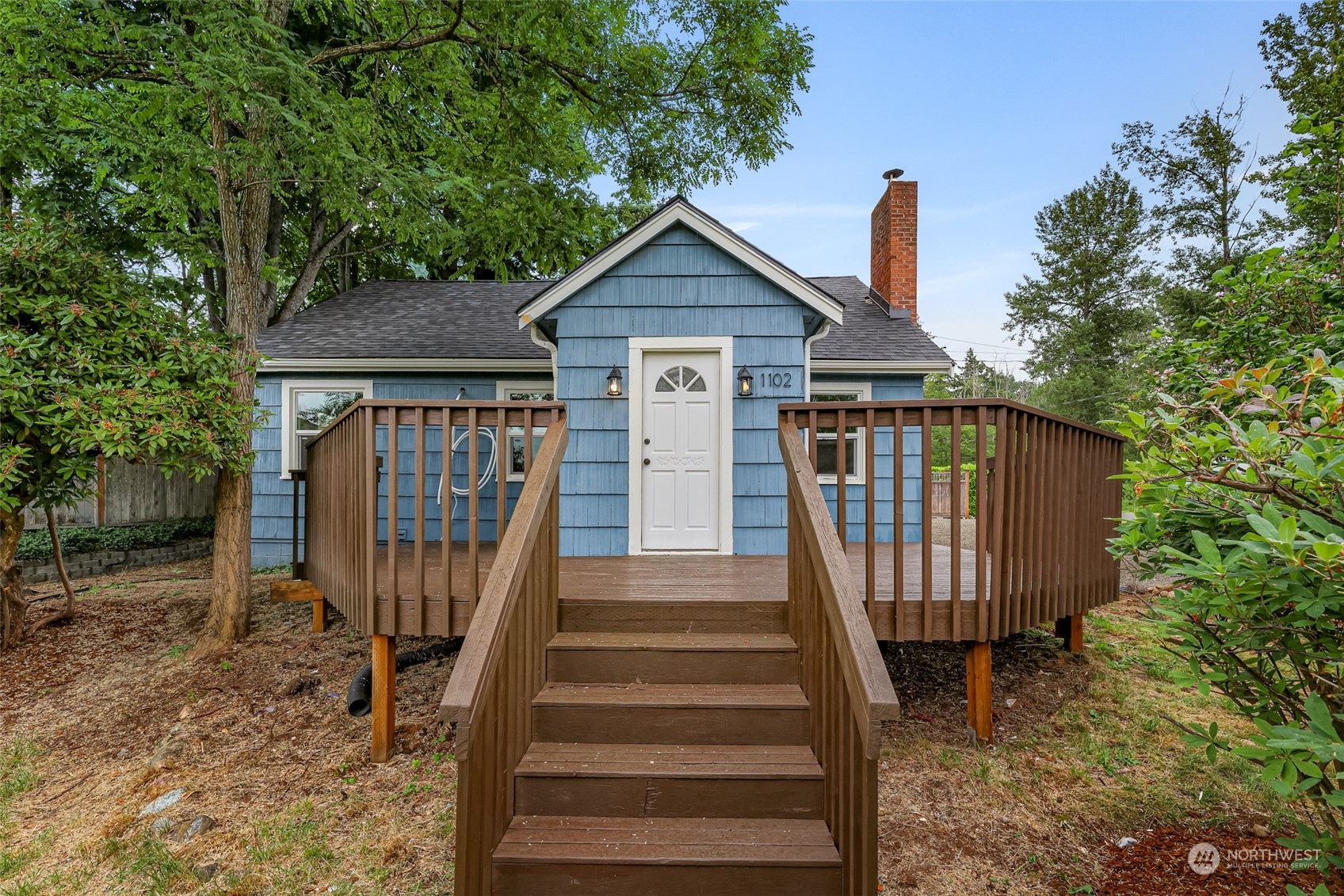 a view of a house with wooden fence next to a yard
