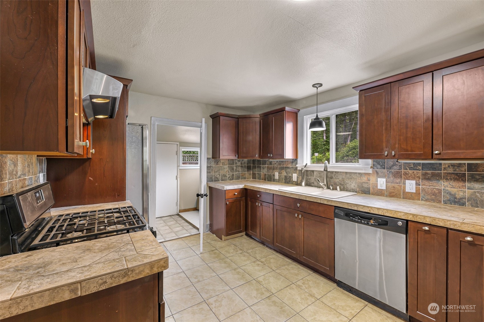 1102 Nevada Street Bellingham, WA 98229 - Photo 14 of 40 a kitchen with stainless steel appliances granite countertop a stove a sink and a refrigerator