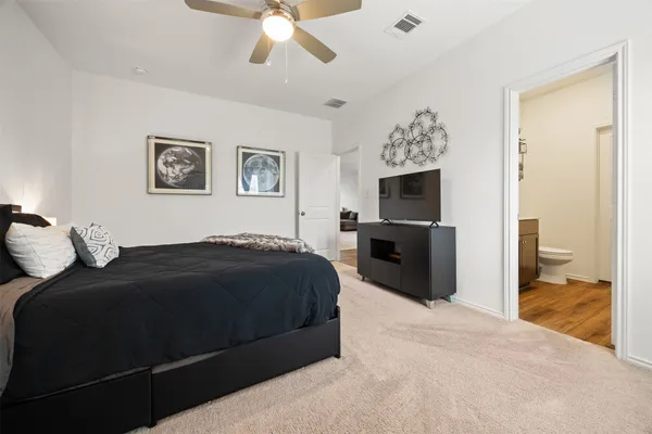 a bedroom with a large bed and a chandelier