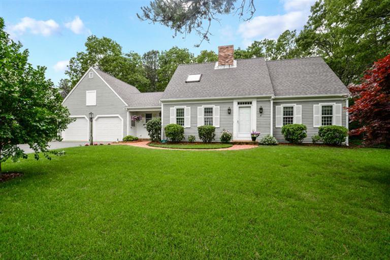 a front view of a house with a garden and plants