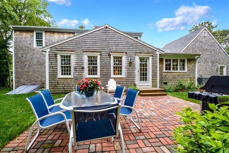 45 Long Hill Road Dennis, MA 02638 - Photo 21 of 26 a view of a house with a table and chairs in patio