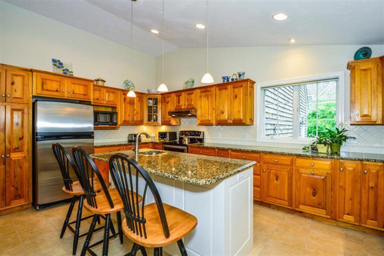 45 Long Hill Road Dennis, MA 02638 - Photo 9 of 26 a kitchen with stainless steel appliances granite countertop a sink and a refrigerator