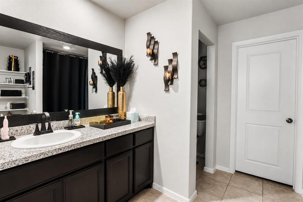 3204 Quiet Valley Road Fort Worth, TX 76123 - Photo 24 of 29 a bathroom with a granite countertop sink two mirror and a