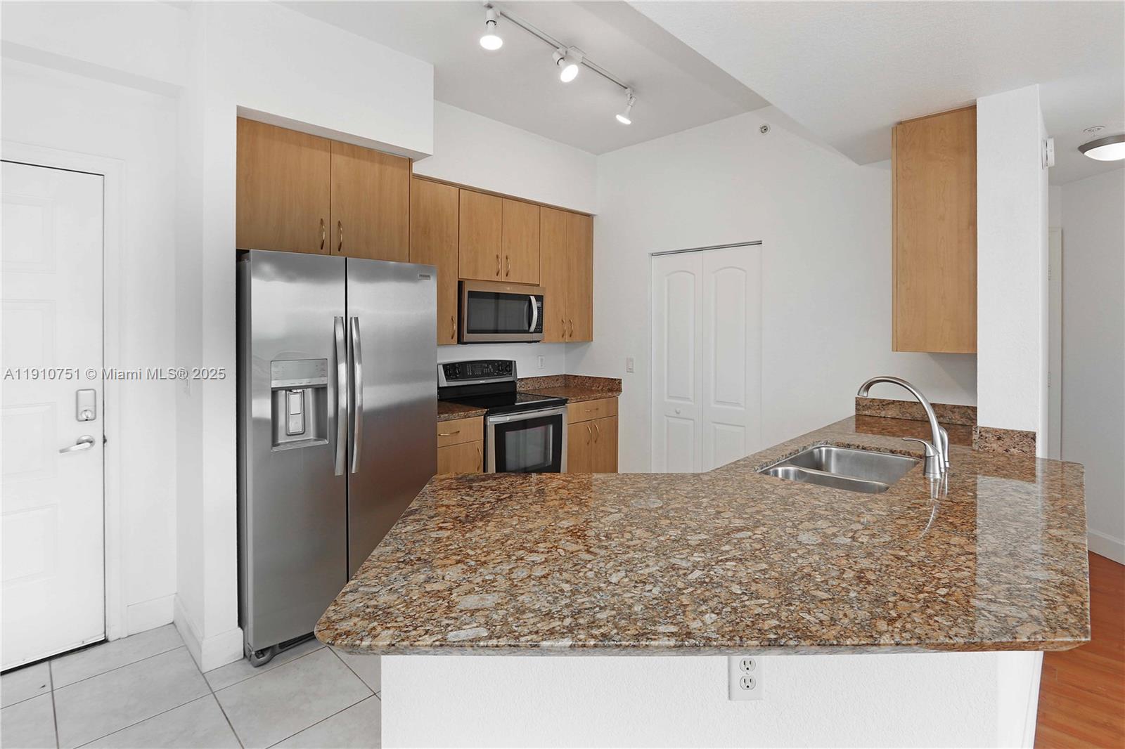 1830 Radius Drive, Unit 1119 Hollywood, FL 33020 - Photo 13 of 53 a kitchen with kitchen island a counter top space cabinets and stainless steel appliances