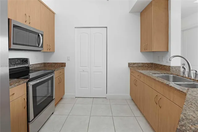 a kitchen with stainless steel appliances granite countertop a sink stove and microwave