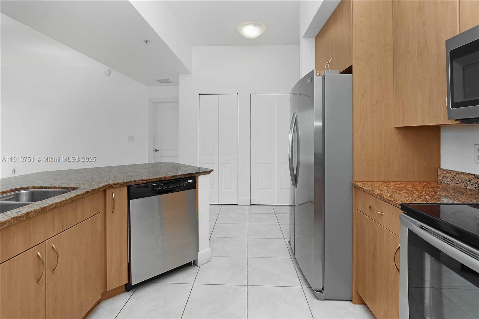 1830 Radius Drive, Unit 1119 Hollywood, FL 33020 - Photo 15 of 53 a kitchen with stainless steel appliances granite countertop a refrigerator and a sink