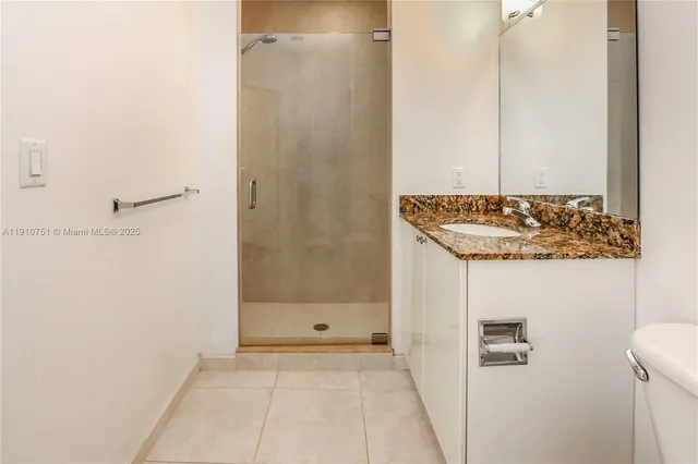 a bathroom with a granite countertop shower and a sink