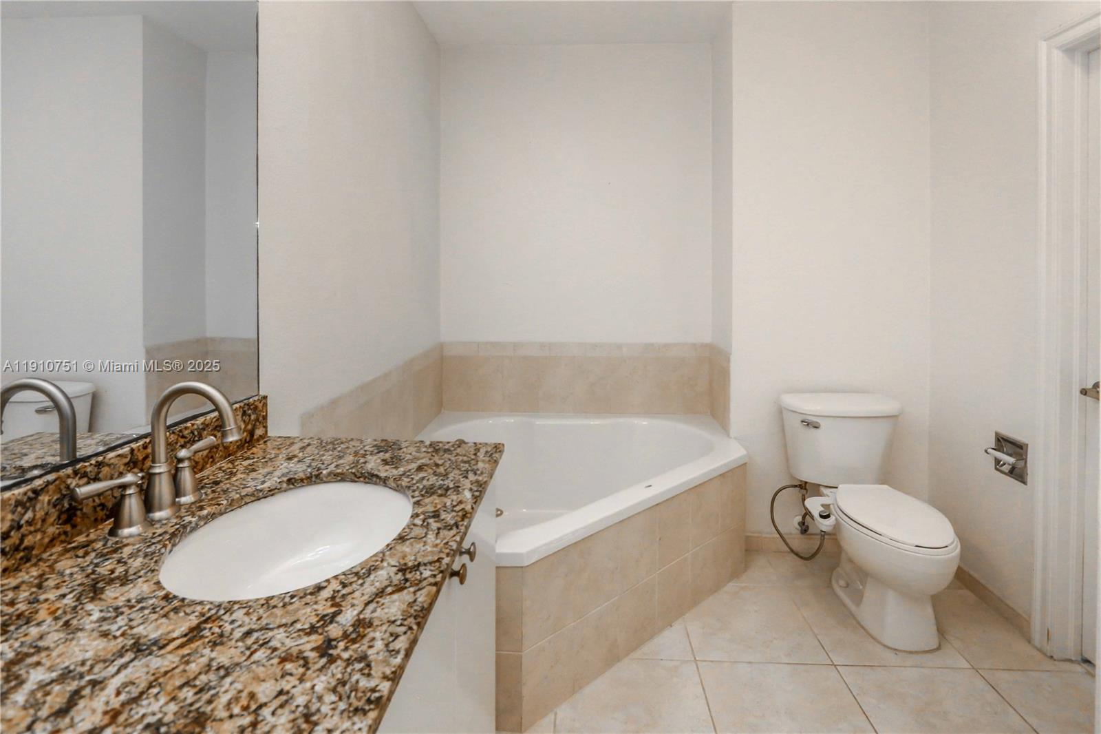 1830 Radius Drive, Unit 1119 Hollywood, FL 33020 - Photo 25 of 53 a bathroom with a granite countertop sink a toilet and bathtub