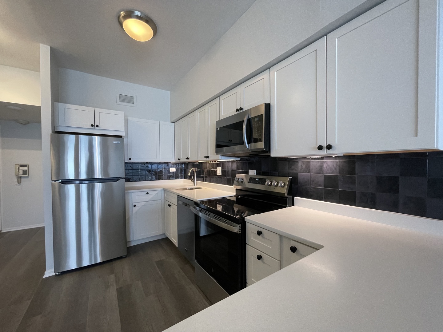 175 East Delaware Place, Unit 5004 Chicago, IL 60611 - Photo 5 of 17 a kitchen with white cabinets and appliances