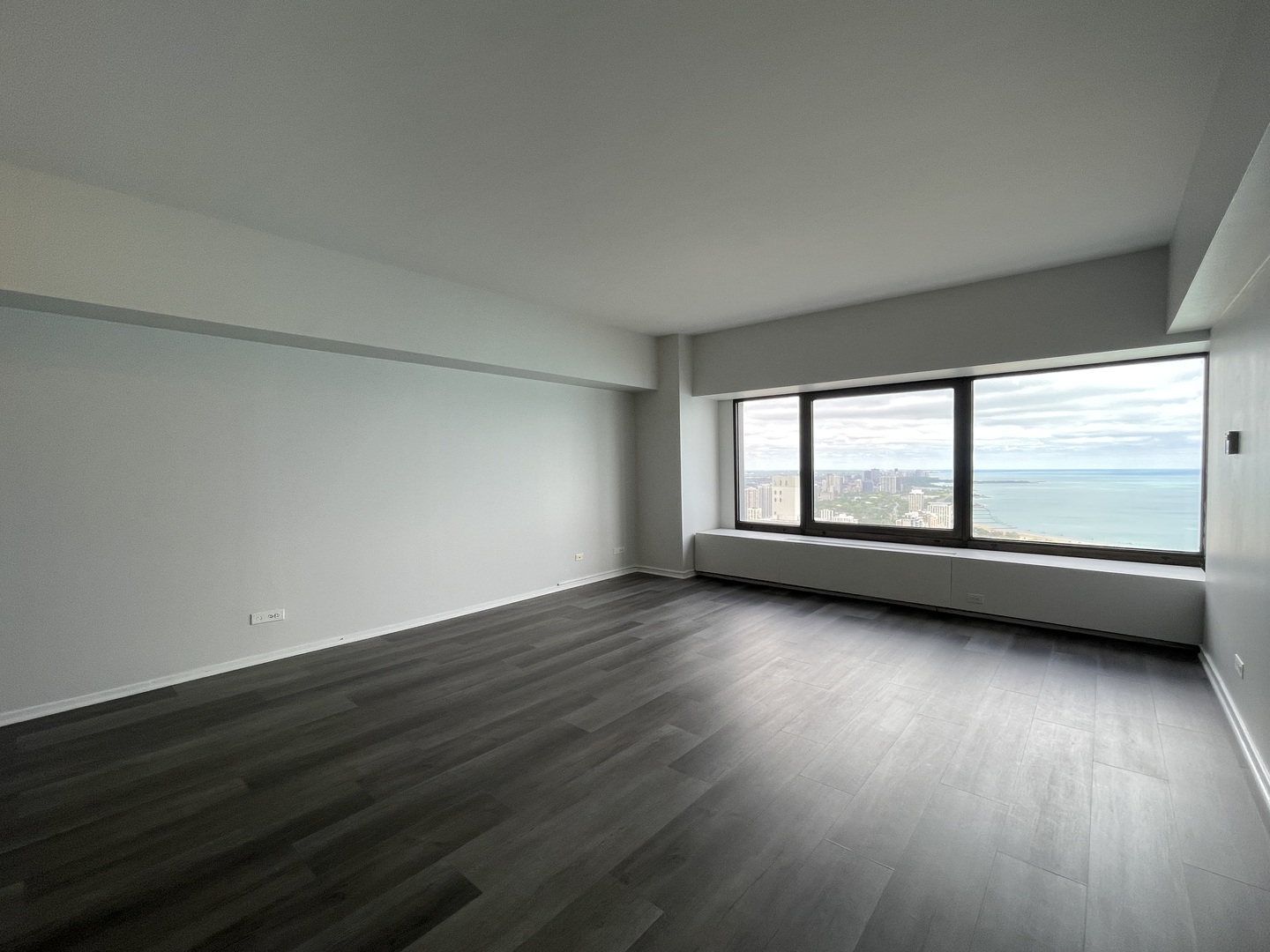 175 East Delaware Place, Unit 5004 Chicago, IL 60611 - Photo 7 of 17 a view of an empty room with wooden floor and a window