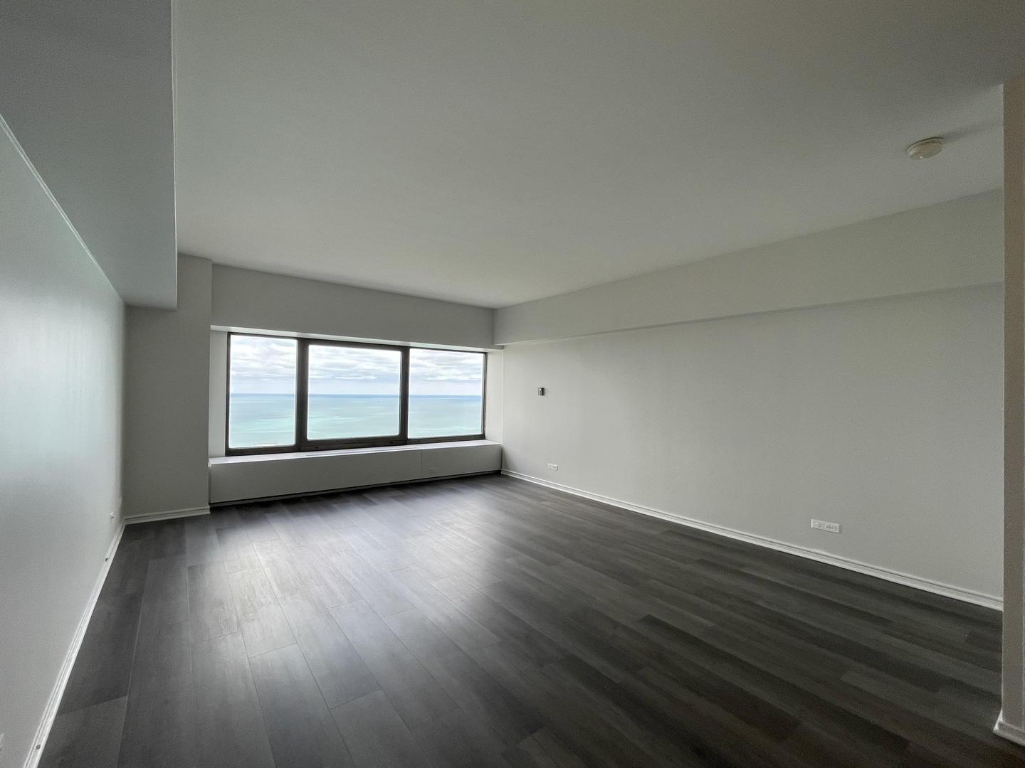 175 East Delaware Place, Unit 5004 Chicago, IL 60611 - Photo 9 of 17 an empty room with wooden floor and windows