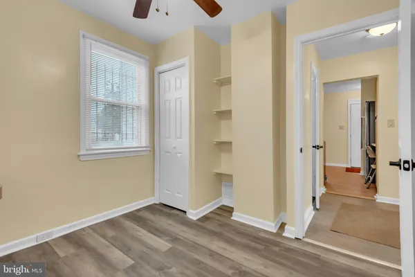 a view of an empty room with a window and wooden floor