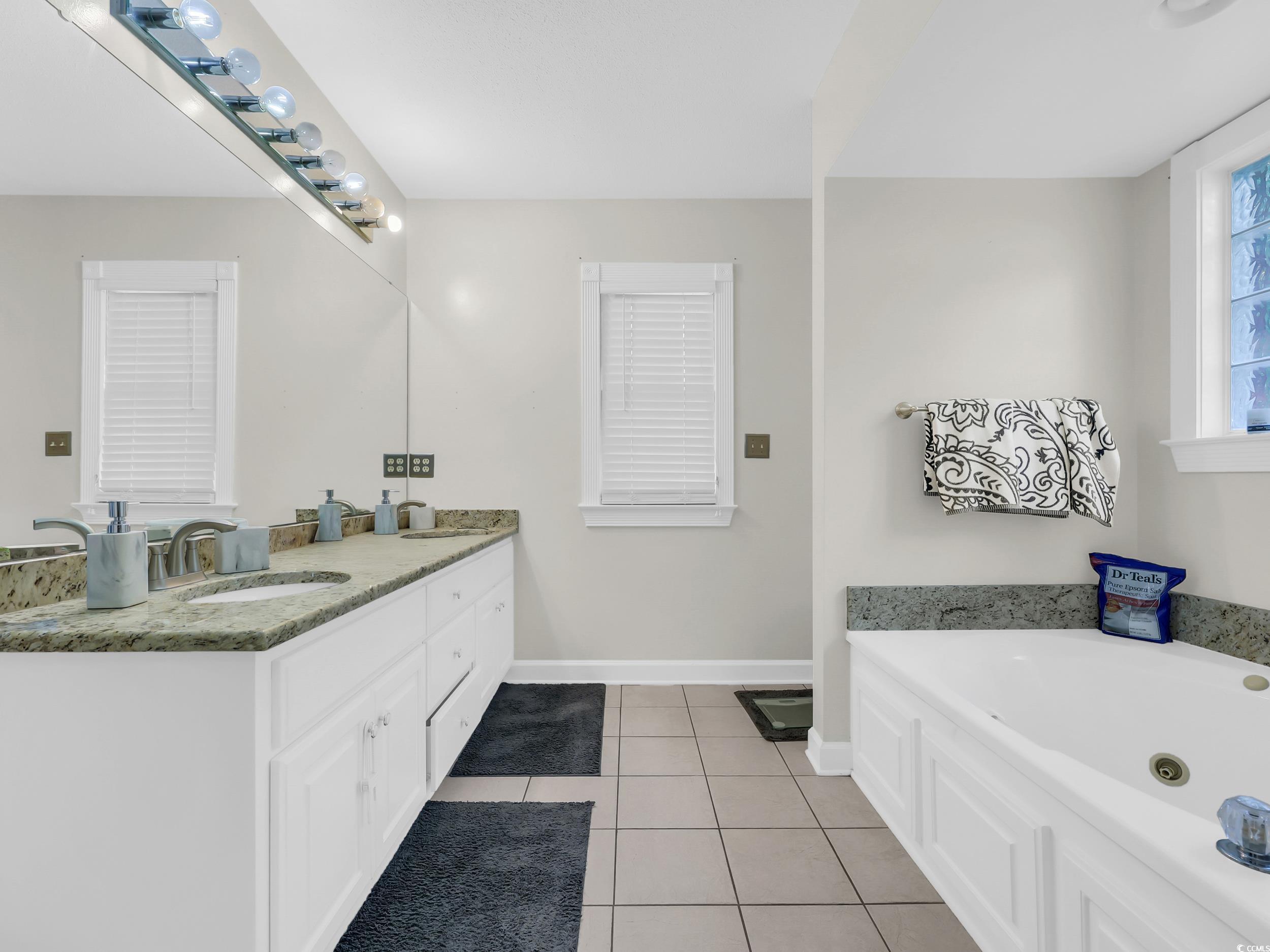 3731 Love Lane Conway, SC 29527 - Photo 15 of 32 Bathroom featuring double vanity, light tile patterned floors, and a whirlpool tub