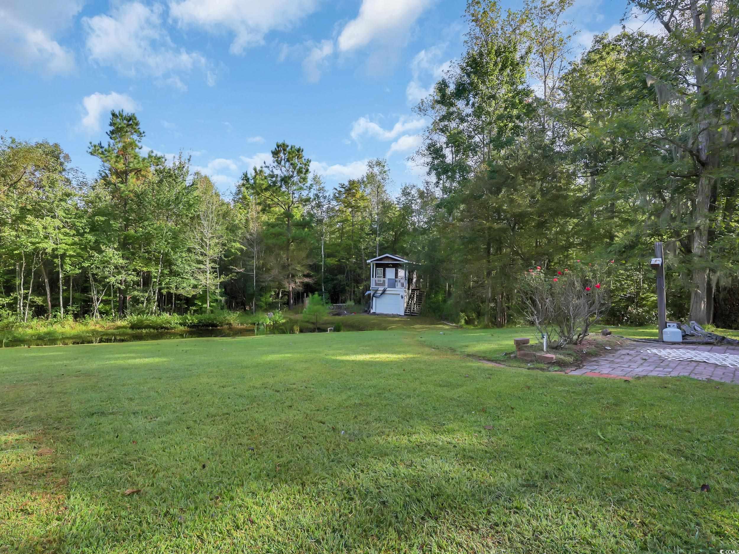 3731 Love Lane Conway, SC 29527 - Photo 27 of 32 View of grassy yard featuring a patio area, view of wooded area, and a water view
