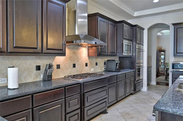 a kitchen with wooden cabinets and a stove top oven