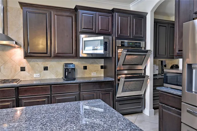 a kitchen with stainless steel appliances granite countertop a refrigerator and a stove