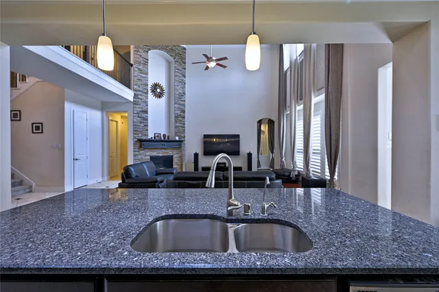 a kitchen with stainless steel appliances kitchen island granite countertop a sink and a refrigerator