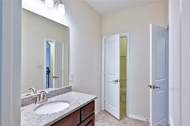 a bathroom with a granite countertop double vanity sink and a mirror
