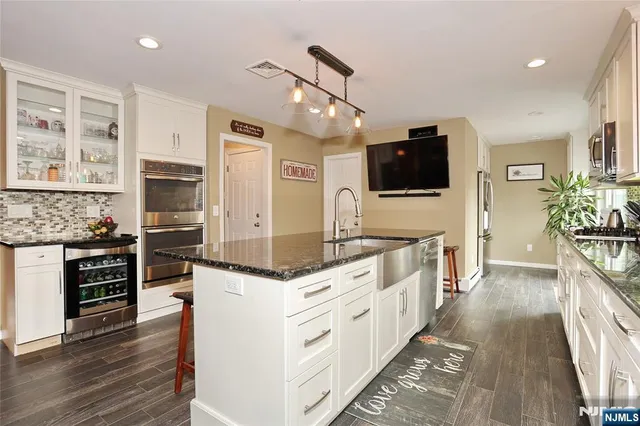 a large kitchen with stainless steel appliances kitchen island granite countertop a stove and a sink
