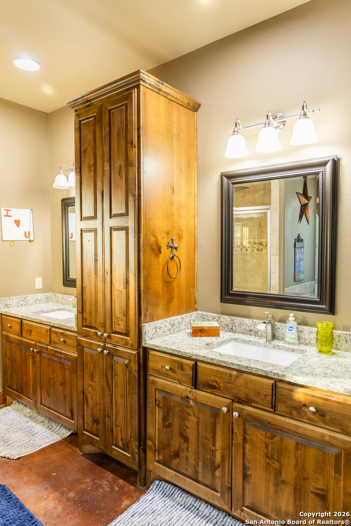 187 Robbins Ranch Road Junction, TX 76849 - Photo 11 of 23 a bathroom with a granite countertop sink and a mirror
