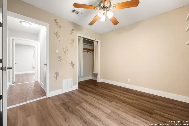 a view of an empty room with wooden floor