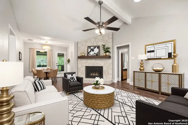 a living room with furniture a fireplace and a chandelier