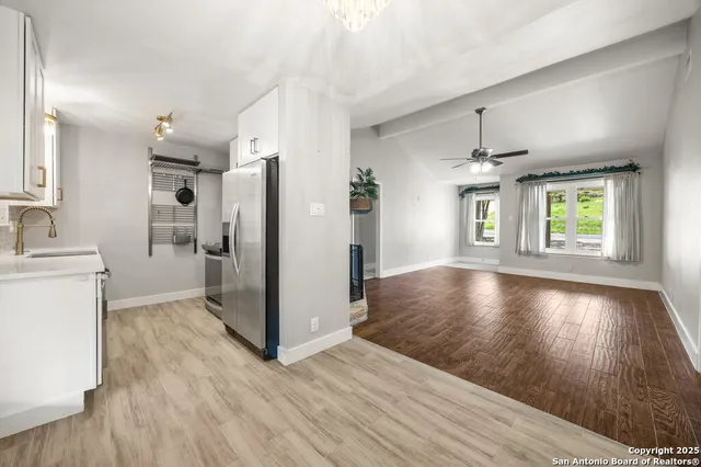 a view of a kitchen with wooden floor and a window
