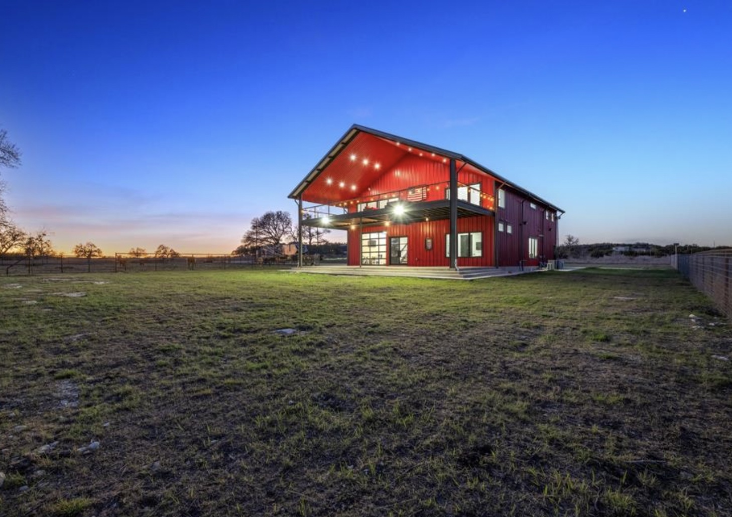 561 Broken Bit Trail Dripping Springs, TX 78620 - Photo 2 of 40 Back of property with a fenced backyard, a patio area, board and batten siding, and a rural view