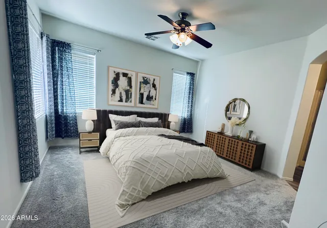 a bedroom with a bed a dresser and chair